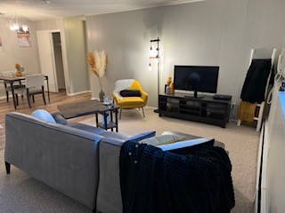A living room with a grey couch and a yellow chair.